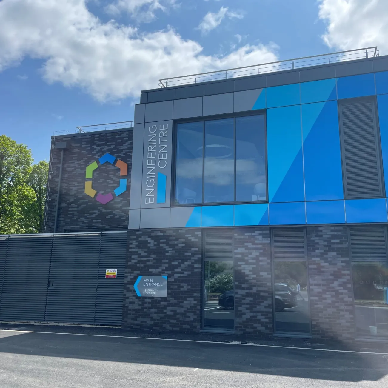 Two-storey modern building with blue panels labelled "Engineering Centre" with a colourful circular logo.