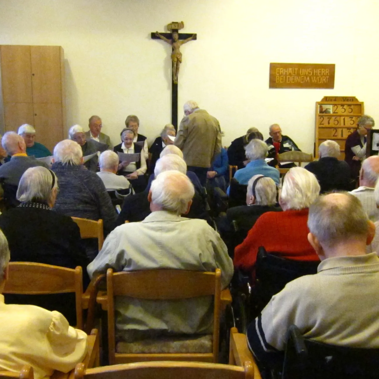 A church service is filled with a congregation of Romanian elders.
