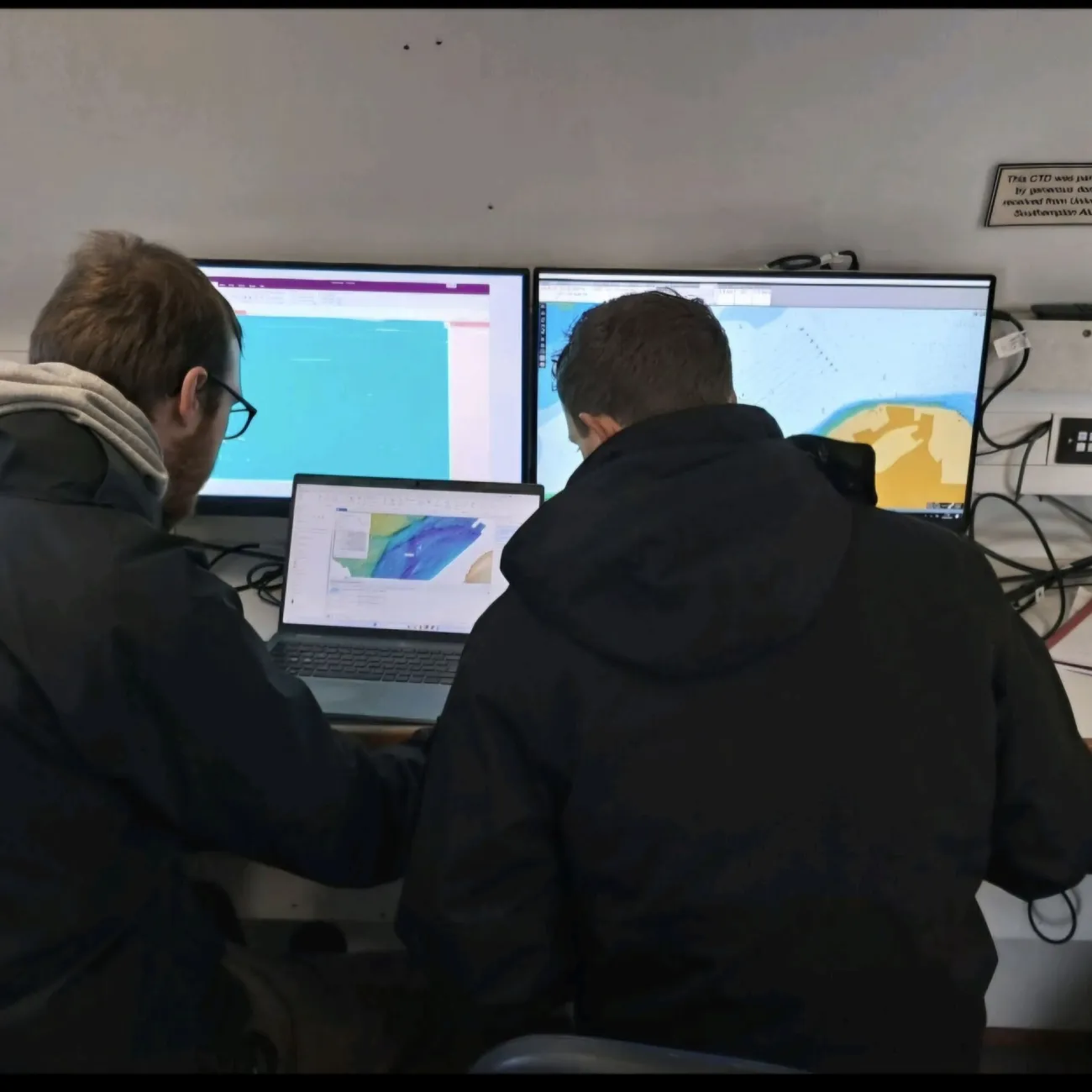 A photo of Enis looking at a computer screen.