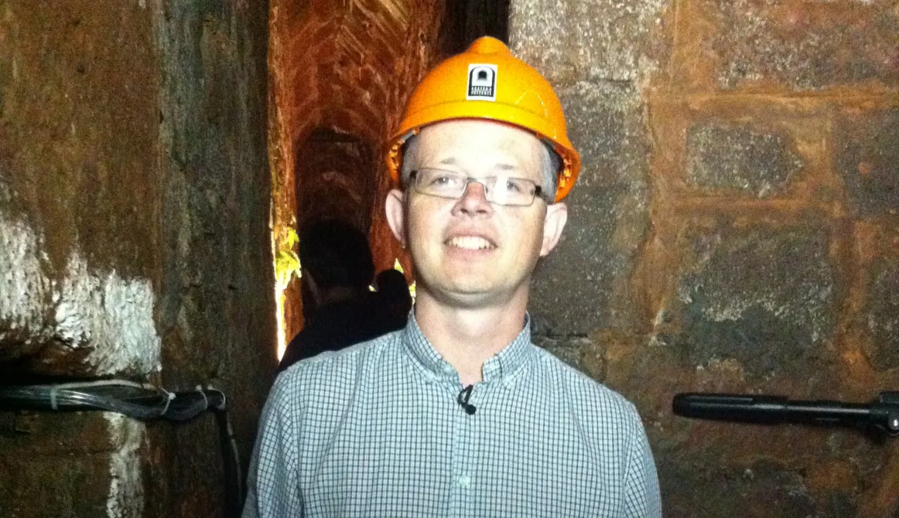Historian Mark Stoyle poses for the camera underground wearing a yellow hard hat