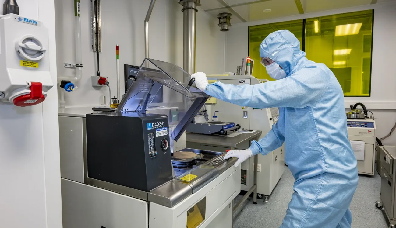 A person in a uniform working at Disco DAD341 wafer saw