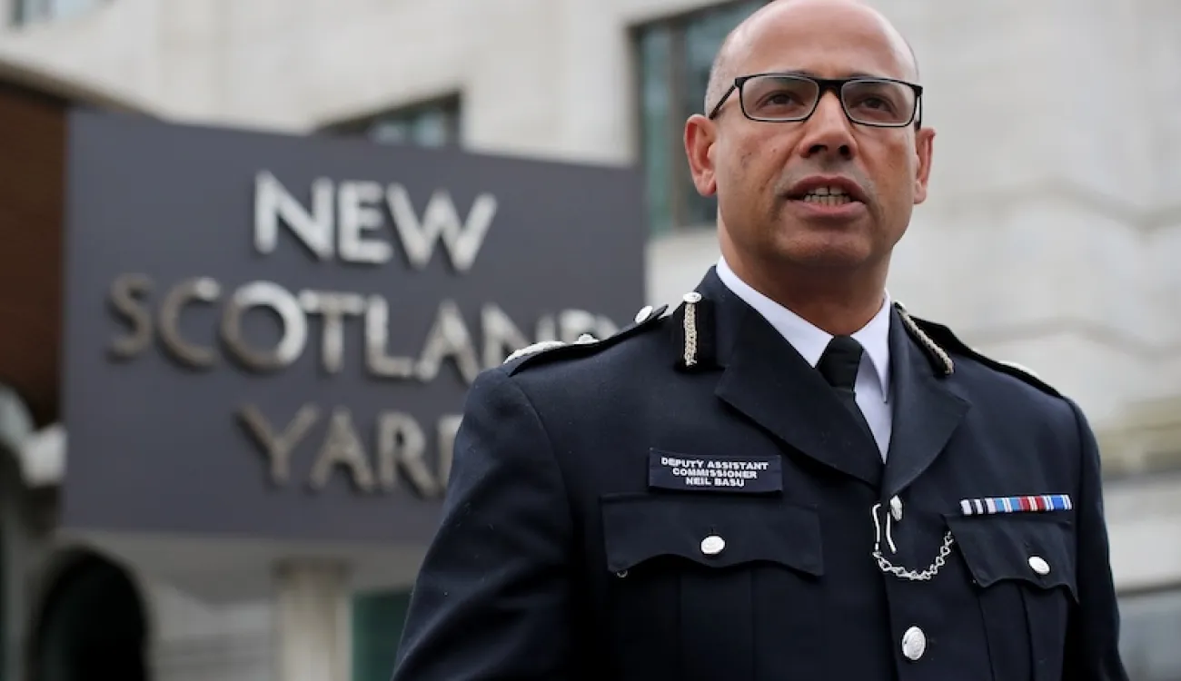 Neil Basu pictured in police uniform in front of New Scotland Yard sign