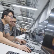 Two students working at a computer in the David Barron computing lab.
