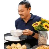 Catering manager Fritz Apellido smiles as he puts coffees on a tray