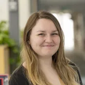 Head and shoulders portrait image of Eleanor Austin, MA Creative Writing student, smiling at the camera.