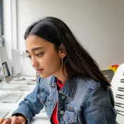 Head and shoulders portrait image of Lavanya Sharma, BA Fashion Marketing with Management student working on a laptop.