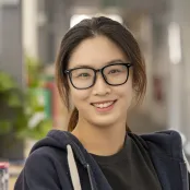 Head and shoulders portrait image of Shuheng Zhang, MA Creative Writing student, smiling at the camera.