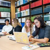 Students sat at table in library