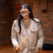 Ouwen Wang is laughing in a rehearsal in the Turner Sims hall.