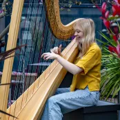 BA Music student Tenzi Williams playing a harp