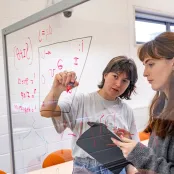 Languages and linguistic students writing phonetic symbols on a board