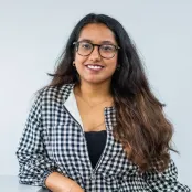 MSc Business Analytics and Management Science student, Chhavi is leaning on a table and smiling at the camera.