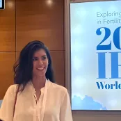 Hannah at the IFFS congress in Athens standing in front of the sign