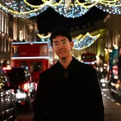 Jiachen is standing in front of christmas lights.