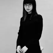 A black and white photo of Tianyu looking at the camera