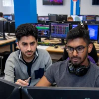 Student and tutor looking at business trading screen.