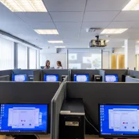 A view of workspaces in the social sciences experimental lab, with two students talking in the background