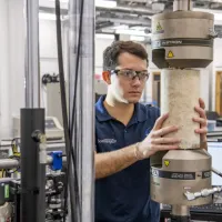 A student tests a concrete structure in the testing and structures research lab