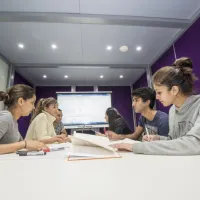 Group of students at work around a table in the maths student centre.