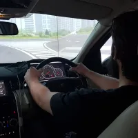 Student with both hands on the wheel of a driving simulator