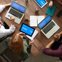 looking downwards at people sitting around a table with their laptops