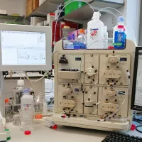 View of a bench with protein analysis equipment and computer screen showing results
