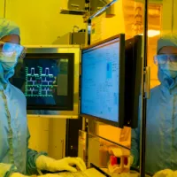 A researcher in a cleanroom suit and wearing a protective glasses, uses the electron beam lithography (EBL) facility