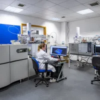 A woman researcher sat in front of a computer screen in a Chromatography-Mass Spectrometry laboratory