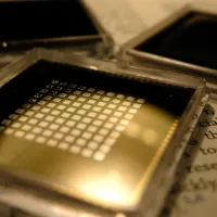 three small square microchips placed on the pages of a book with visible text.