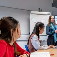 Lecturer presenting research project structure to students in class.
