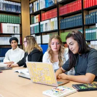 Students sat at table in library