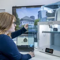 A student inspecting the finished construction of her latest 3D printed object.