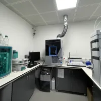 Analytical area at the environmental laboratory with advanced scientific instruments, computer monitor, and exhaust pipe