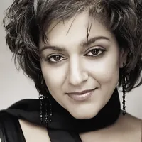 Close up of Meera Syal in black scarf, facing camera