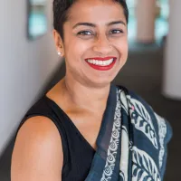 Medium shot of Poppy Jaman wearing a saree and smiling at the camera