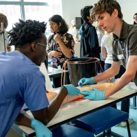 A small group of young people, engaged in a practical medical summer school session to find out what it’s like to be a doctor.