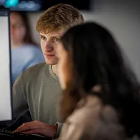 Two students looking at a computer screen.