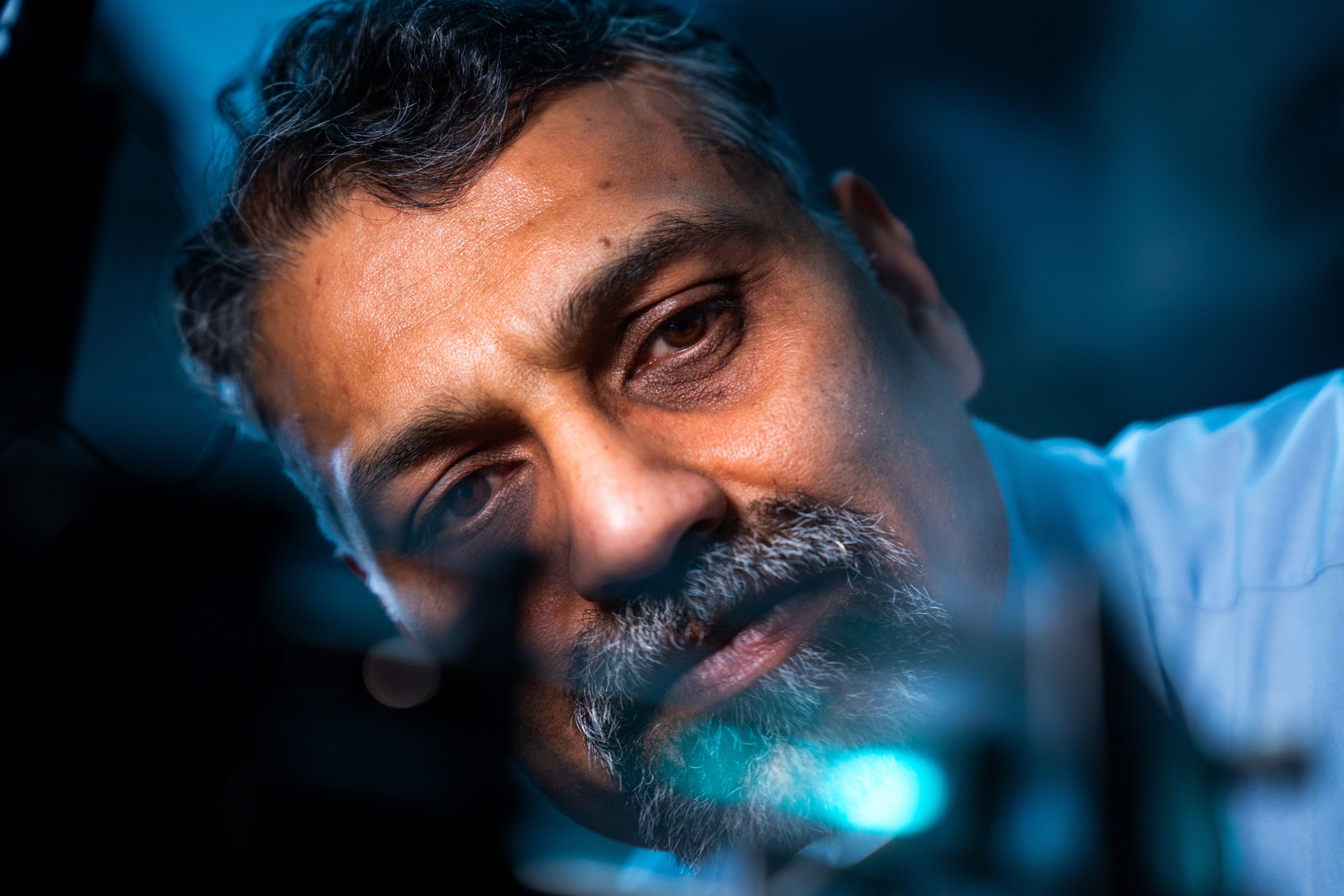 Professor Sumeet Mahajan examining optical imaging equipment in a molecular biophotonics laboratory.